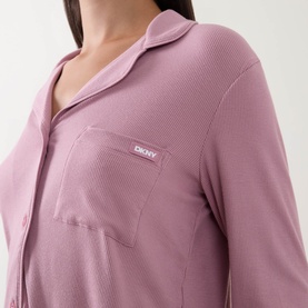 Model wearing DKNY Notched Collar Long-Sleeved Pyjama Set in Dusty Mauve, showing ribbed texture, logo chest patch pocket and button fastening.