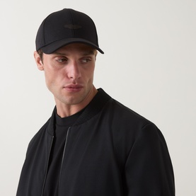 Model with Boss Black Casual Zef Suede Logo Baseball Cap in black, six-panel construction with tonal stitching, styled with black bomber jacket