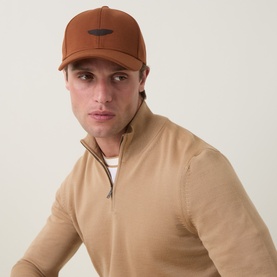 Model with Boss Black Casual Zef Suede Logo Baseball Cap in Open Brown, suede logo patch, peaked visor, styled with beige zip-neck knit