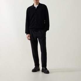 Model wearing Boss Black Casual Laconico Knitted Polo Cardigan in black with black trousers and chunky black loafers.