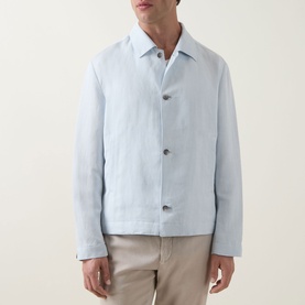 Model wearing Boss Black Casual Open Blue linen-lyocell casual jacket with button front, styled with white polo and beige trousers.