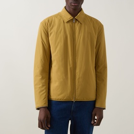Model wearing Boss Black Casual gold casual jacket with zip front, spread collar, styled with blue jeans.
