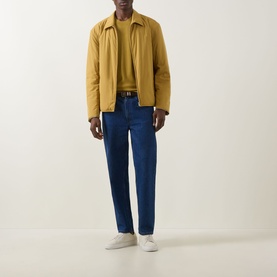 Model wearing Boss Black Casual gold casual jacket with blue jeans, brown belt and white trainers