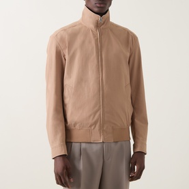Model wearing Boss Black Casual Medium Beige casual jacket with funnel neck and zip front, styled with grey trousers.