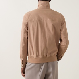 Model wearing Boss Black Casual Medium Beige casual jacket, rear view, showing ribbed hem, cuffs and funnel collar, styled with light grey trousers