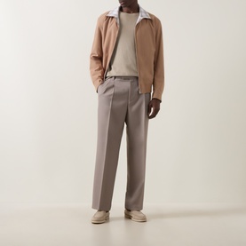Model wearing Boss Black Casual Medium Beige casual jacket, styled with grey trousers, white T-shirt and cream trainers.