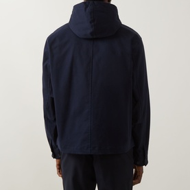 Model wearing Boss Black Casual dark blue casual jacket, rear view, hooded with centre back seam, paired with black trousers.