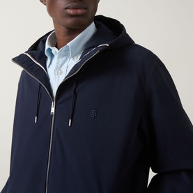 Model wearing Boss Black Casual dark blue casual jacket with hood and zip fastening, styled with a light blue shirt underneath.
