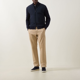 Model wearing Boss Black Casual dark blue casual jacket with zip front, styled with beige chinos and navy trainers.
