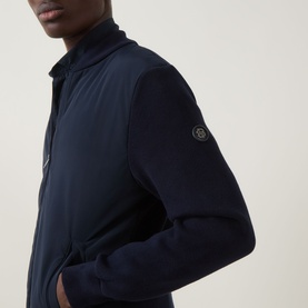 Model wearing Boss Black Casual dark blue casual jacket with zip front, contrast panelling, and branded logo badge on sleeve.