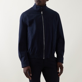 Model wearing navy zip-up harrington jacket with funnel neck and silver-tone zip, styled with navy trousers