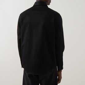 Model wearing Boss Black Casual Owen Solid Logo Shirt in black, rear view, styled with dark trousers.