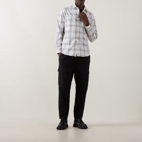 Model wearing Boss Black Casual Owen Flap Pocket Check Shirt in Open White with black cargo trousers and black shoes.