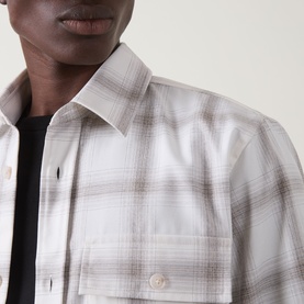 Model wearing Boss Black Casual Owen Flap Pocket Check Shirt in Open White, check print, point collar, layered over black crew neck top.