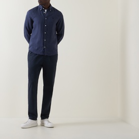 Model wearing Boss Black Casual Liam Logo Linen Shirt in dark blue with button-down collar, styled with navy trousers and white trainers.