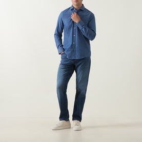 Model wearing Boss Black Casual Rob Denim Shirt in Open Blue with dark blue jeans and white trainers