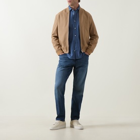 Model wearing Boss Black Casual Rob Denim Shirt in Open Blue, styled with tan bomber jacket, dark blue jeans and white trainers.