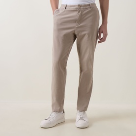 Model wearing Boss Black Casual Open Beige cotton casual trousers with slim fit, styled with white trainers.