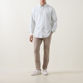 Model wearing Boss Black Casual Open Beige slim-fit casual trousers in cotton blend, styled with white shirt and white trainers.