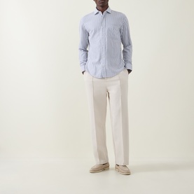 Model wearing Boss Black Casual Rob Striped Shirt in dark blue stripe, with cream wide-leg trousers and beige suede loafers.