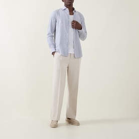 Model wearing Boss Black Casual Rob Striped Shirt in dark blue stripe, paired with cream wide-leg trousers and beige loafers