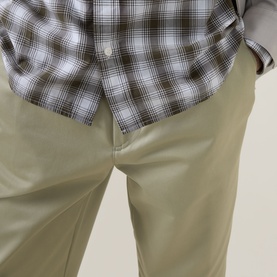 Model wearing Boss Black Casual Kai Pleated Trousers in Dark Beige, styled with a grey plaid shirt. Mid-rise straight-leg fit with front pleats.