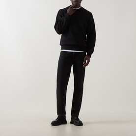 Model wearing Boss Black Casual black cotton crew neck sweatshirt, styled with black trousers and black leather shoes.