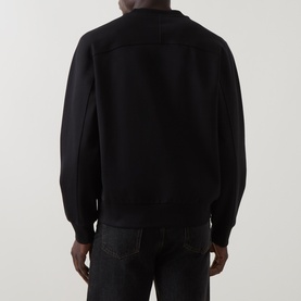 Model wearing Boss Black Casual black cotton crew neck sweatshirt, rear view, styled with dark denim jeans.