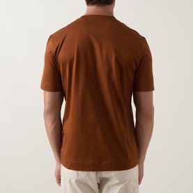 Model wearing Boss Black Casual medium brown crew neck T-shirt, rear view, styled with light beige trousers.