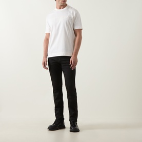 Model wearing Boss Black Casual Taut Logo T-Shirt in Open White, styled with black slim-fit jeans and black leather boots.