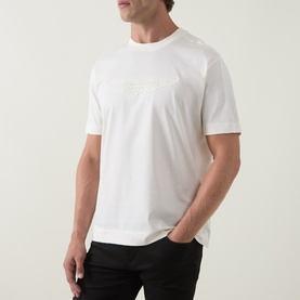 Model wearing Boss Black Casual Taut Logo T-Shirt in Open White, crew neck with tonal chest logo, short sleeves, paired with black trousers.
