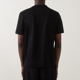 Model wearing Boss Black Casual Taut Logo T-Shirt in black, shown from behind, with short sleeves and straight hemline. Styled with black trousers.