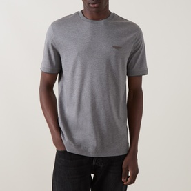 Model wearing Boss Black Casual Thompson Logo T-Shirt in Open Grey, crew neck, short sleeves, tonal chest logo, paired with dark jeans