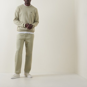 Model wearing Boss Black Casual C-Sharpe Logo Sweatshirt in dark beige, crew neck with ribbed trims, styled with matching chinos and white trainers.