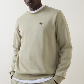 Model wearing Boss Black Casual C-Sharpe Logo Sweatshirt in dark beige, crew neck with small logo embroidery, styled over white crew neck tee