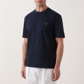 Model wearing Boss Black Casual C-Taut 01 Logo T-Shirt in dark blue, crew neck with chest logo, styled with white trousers.