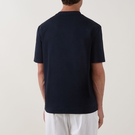Model wearing Boss Black Casual C-Taut 01 Logo T-Shirt in dark blue, rear view, crew neck, short sleeves, styled with white trousers