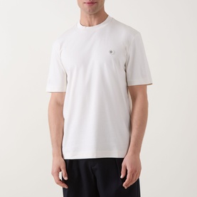 Model wearing Boss Black Casual C-Taut 01 Logo T-Shirt in Open White, crew neck, short sleeves, small chest logo, paired with dark trousers