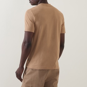 Model wearing Boss Black Casual C-Thompson Logo T-Shirt in medium beige, rear view, short sleeves, styled with matching beige trousers.