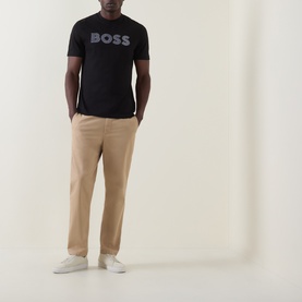 Model wearing Boss Black Casual C-Thompson Logo T-Shirt in black with beige chinos and white trainers.
