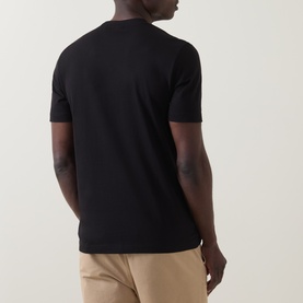 Model wearing Boss Black Casual C-Thompson Logo T-Shirt in black, rear view, crew neck, short sleeves, styled with beige trousers