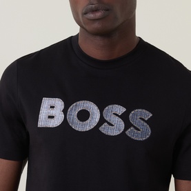 Model wearing Boss Black Casual C-Thompson Logo T-Shirt in black, close-up showing textured houndstooth BOSS lettering on chest.