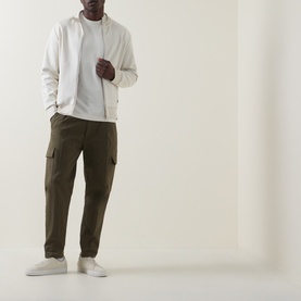Model wearing Boss Black Casual C-Tigerman Open White crew neck T-shirt, styled with olive cargo trousers and white trainers.