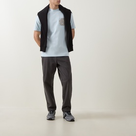 Model wearing Boss Black Casual Tigerman Logo T-Shirt in Open Blue with black gilet, dark grey trousers and grey trainers.