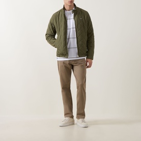 Model wearing Boss Black Casual Tigerman Stripe T-Shirt in White, styled with olive quilted jacket, tan chinos and white trainers.