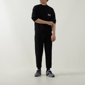 Model wearing Boss Black Casual C-Tigerman Logo Sweatshirt in black with matching black trousers and grey trainers.