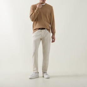 Model wearing Boss Black Casual Leno Knitted Sweater in medium beige, crew neck, fine-knit wool, styled with cream trousers and white trainers