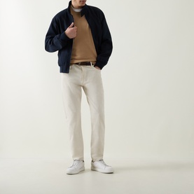 Model wearing Boss Black Casual Leno Knitted Sweater in medium beige, crew neck, styled with navy zip jacket, cream trousers and white trainers.