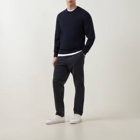Model wearing Boss Black Casual Leno Knitted Sweater in dark blue, styled with dark grey trousers and white trainers.