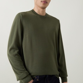 Model wearing Boss Black Casual Leno Knitted Sweater in Open Green, crew neck, fine-knit, long sleeves, styled with dark jeans